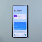 A Samsung Phone screen displaying a daily briefing page titled End of the day featuring weather updates, activity metrics, and YouTube post schedules on a light blue background.