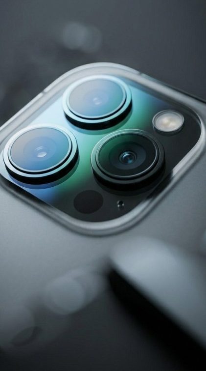 Close-up of a triple-lens camera module on a grey matte finish smartphone.